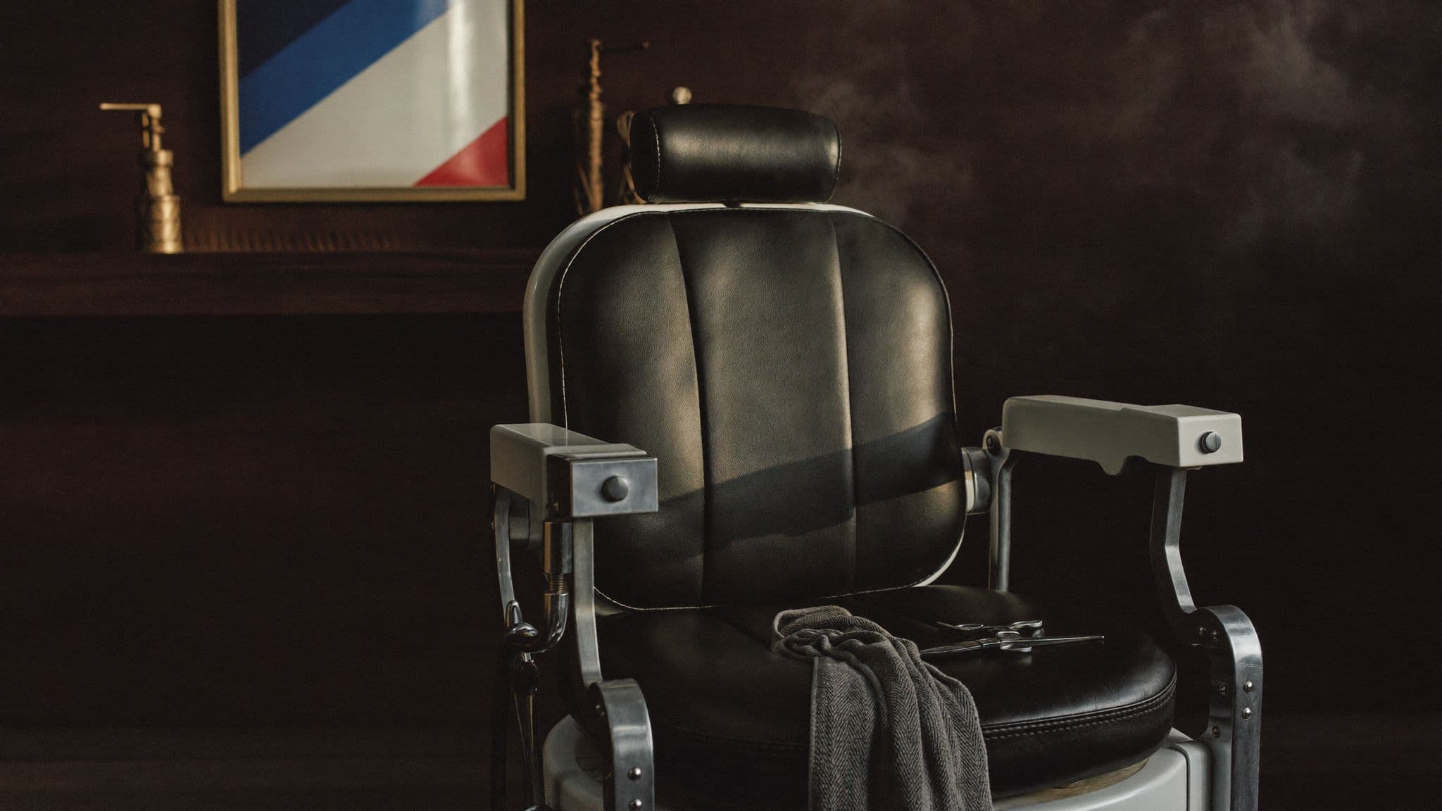 Warm beleuchteter Barbierstuhl aus Leder mit Werkzeugen im Ayaz Barbershop